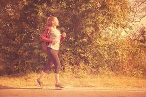 donna che fa jogging lungo una strada di campagna foto