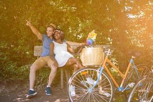 giovane coppia multietnica che fa un giro in bicicletta nella natura foto