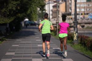 giovane sorridente multietnico coppia jogging nel il città foto