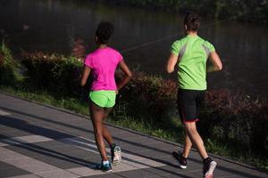 giovane sorridente multietnico coppia jogging nel il città foto