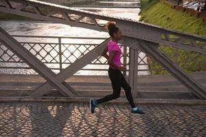 africano americano donna in esecuzione attraverso il ponte foto