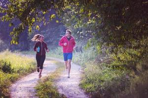 giovane coppia fare jogging lungo una strada di campagna foto
