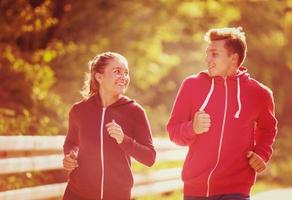 giovane coppia fare jogging lungo una strada di campagna foto