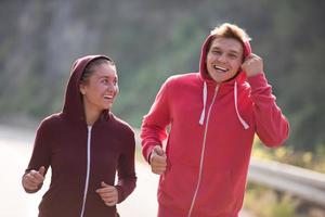 giovane coppia fare jogging lungo una strada di campagna foto