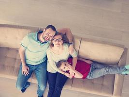 famiglia con poco ragazzo gode nel il moderno vivente camera foto