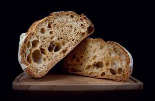 un' pagnotta di segale pane tagliare nel metà su un' di legno taglio tavola. fatto in casa pane . foto