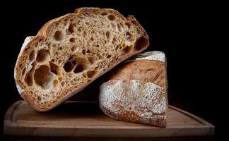 un' pagnotta di segale pane tagliare nel metà su un' di legno taglio tavola. foto