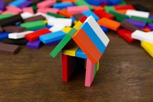 il domino multi colore costruire casa su tavola di legno immagine. foto