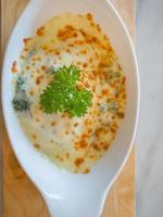 spinaci con formaggio in una ciotola bianca su piatto di legno piatto laico immagine. foto