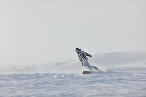 lo snowboarder freestyle salta e cavalca foto