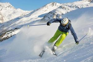 sciare sulla neve fresca nella stagione invernale in una bella giornata di sole foto