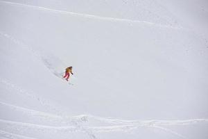 sciatore freeride che scia nella neve farinosa profonda foto