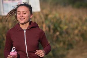 donna che fa jogging lungo una strada di campagna foto