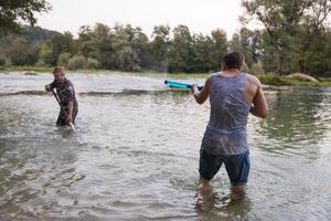 giovane uomini avendo divertimento con acqua pistole foto