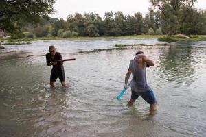 giovane uomini avendo divertimento con acqua pistole foto