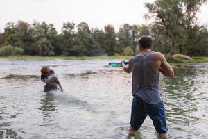 giovane uomini avendo divertimento con acqua pistole foto