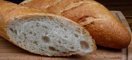 affettato fresco croccante baguette su un' di legno taglio tavola. arte pane. foto