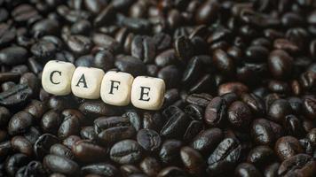 immagine ravvicinata del cubo di legno del testo e del caffè torrefatto. foto