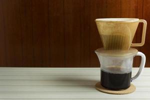 tazza di gocciolamento di caffè sul tavolo bianco per l'immagine di sfondo. foto