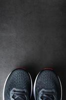 nero gli sport scarpe da ginnastica con rosso suole su un' nero sfondo. foto