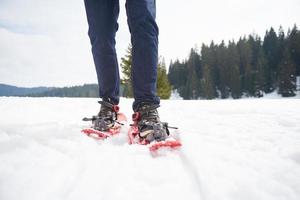 coppia divertendosi e camminando con le racchette da neve foto