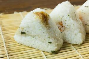 il cibo giapponese onigiri riso bianco formato in forme triangolari o cilindriche e spesso avvolto in nori. foto