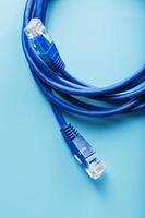 Due ethernet cavo connettori toppa cordone cordone avvicinamento isolato su un' blu sfondo con gratuito spazio foto