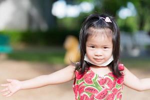 3-4 anno vecchio ragazza sorrisi e sembra a telecamera. bambini mettere maschera sotto loro mento. bambino ha sudore perline su il suo fronte. ragazzo giocare nel caldo sole. bambino diffusione loro braccia per impedire loro a partire dal passaggio di. foto