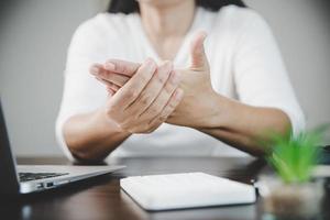 artrite persona, dito donna dolore a partire dal Lavorando nel ufficio. concetto ufficio sindrome mano dolore a partire dal professionale patologia, donna avendo polso dolore a partire dal utilizzando il computer portatile computer, polso dolore. foto