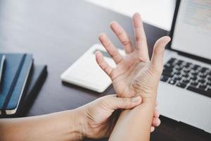 artrite persona, dito donna dolore a partire dal Lavorando nel ufficio. concetto ufficio sindrome mano dolore a partire dal professionale patologia, donna avendo polso dolore a partire dal utilizzando il computer portatile computer, polso dolore. foto