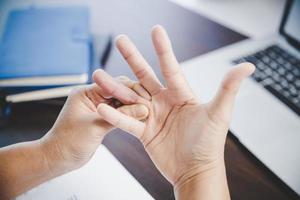 artrite persona, dito donna dolore a partire dal Lavorando nel ufficio. concetto ufficio sindrome mano dolore a partire dal professionale patologia, donna avendo polso dolore a partire dal utilizzando il computer portatile computer, polso dolore. foto