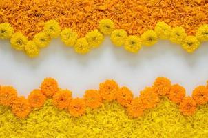 decorativo giallo e arancia colore calendula fiori e petali rangoli per Diwali Festival con bianca spazio sfondo. foto