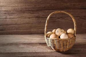 uova nel un' di vimini cestino su di legno tavolo foto