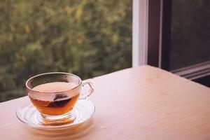 un' tazza di tè su il di legno tavolo, tè Borsa nel bicchiere, natura sfondo. gratuito spazio per testo foto