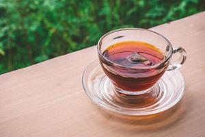 un' tazza di tè su il di legno tavolo, tè Borsa nel bicchiere, natura sfondo. gratuito spazio per testo foto