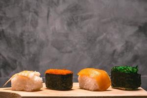 Sushi impostato su di legno piatto su grigio grunge sfondo, giapponese cibo. foto