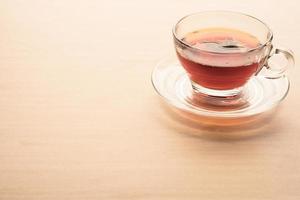 un' tazza di tè su il di legno tavolo, tè Borsa nel bicchiere. foto