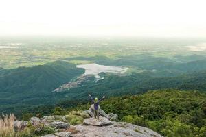 giovane uomo godendo un' valle Visualizza a partire dal superiore di un' montagna. foto
