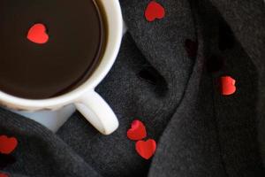 accogliente morbido grigio sciarpa con un' tazza di caffè. mattina. San Valentino giorno foto