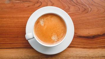 superiore Visualizza di caffè tazza con schiuma su di legno tavolo.primo piano foto