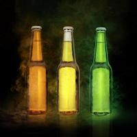 birra bottiglia con acqua gocce su il colore Fumo nero sfondo foto