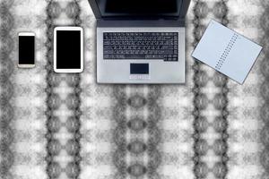 il computer portatile e tavolo spazio di lavoro ufficio su astratto modello foto