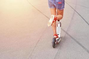 vicino su di donna guida su scooter nel lei città foto