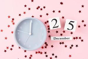 Natale sfondo con allarme orologio e stelle coriandoli su rosa sfondo foto