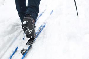 piedi di un' sciatore nel sciare stivali su sci di fondo sci. a piedi nel il neve, inverno gli sport, salutare stile di vita. avvicinamento, copyspace foto