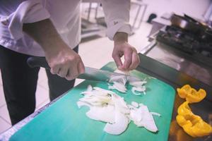 mani dello chef che tagliano verdure fresche e deliziose foto