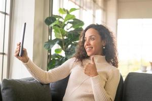 videoconferenza donna latina su tablet con sensazione felice foto