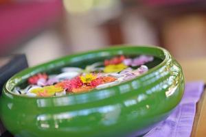 tazza d'acqua con bellissimi fiori sullo sfondo foto