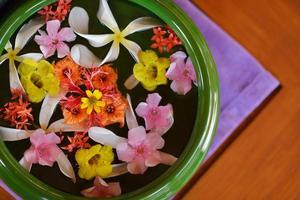 tazza d'acqua con bellissimi fiori sullo sfondo foto