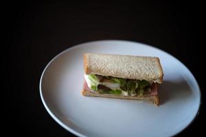 panini con uovo, prosciutto e crostini formaggio fritte nel bianca piatto foto